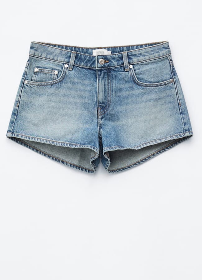 A pair of light blue denim shorts with front and back pockets, a button and zip fastening, and a slightly frayed hem, laid flat on a white background—perfect for those seeking the best denim shorts this season.
