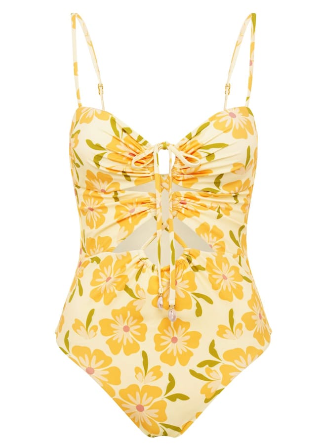 Yellow one-piece swimming costume with pink and orange floral pattern, ruched front detail, adjustable spaghetti straps, and small cut-out below the bust—perfect for those wondering what to wear in Ibiza.