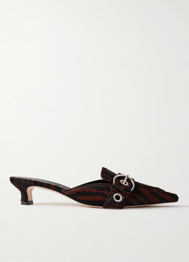 A low-heeled mule shoe with a dark brown and black striped pattern, featuring a pointed toe, a silver buckle detail, and a small block heel—perfect for stepping out in style during the summer sale.