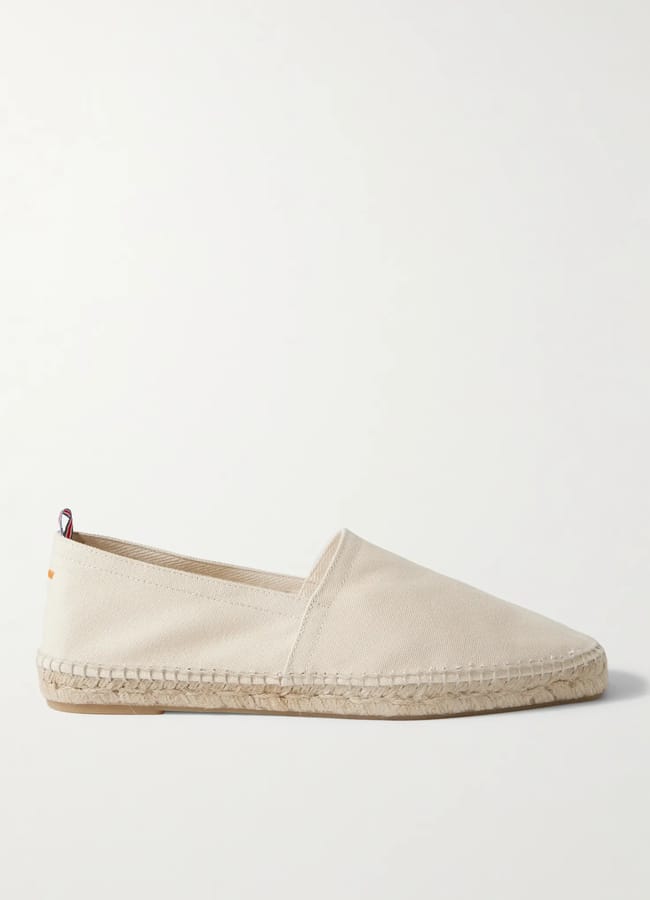 A beige slip-on espadrille shoe with a woven jute sole, seen from the side against a plain white background—perfect for men’s summer dressing and reminiscent of The Talented Mr Ripley style.
