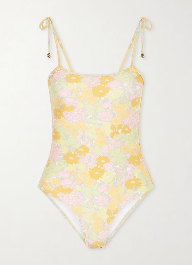 One-piece swimming costume with a yellow, pink, and green floral pattern. This pretty swimwear features thin shoulder straps tied in bows at the top and a scoop neckline.