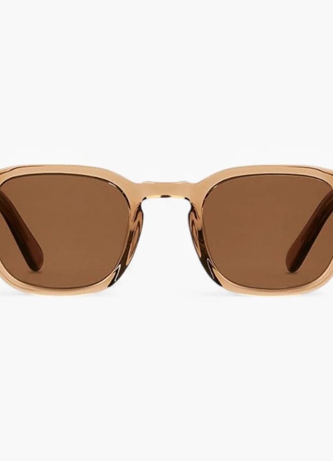 A pair of sunglasses with light brown, translucent frames and brown tinted rectangular lenses, shown from the front on a white background—perfect for elevating men’s summer dressing with a nod to The Talented Mr Ripley style.