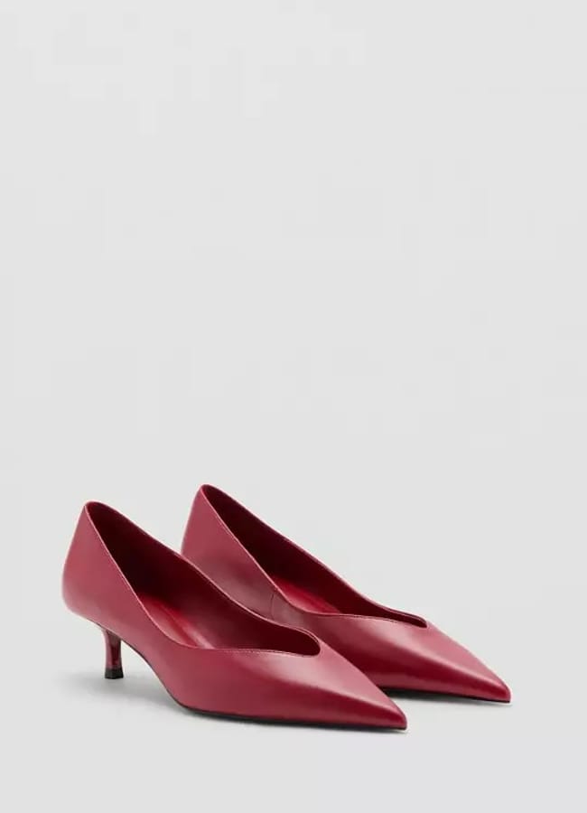 A pair of red, low-heeled, pointed-toe women's shoes is displayed against a plain light grey background, offering an elegant addition to your oversized shirt outfit ideas.