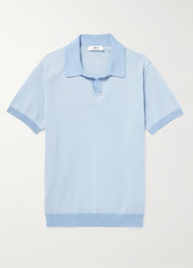 Light blue short-sleeve knitted polo shirt with a collar and a partially open placket, laid flat on a white background. With ribbed cuffs and hem, this classic piece nods to The Talented Mr Ripley style—a timeless staple for men’s summer dressing and refined men’s fashion.