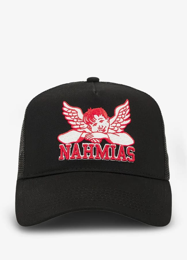 A black trucker hat with a red and white winged cherub graphic and the word NAHMIAS embroidered on the front—perfect for channelling effortless Celebrity Couples On Holiday style.