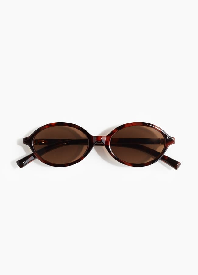 Brown oval sunglasses with tortoiseshell frames, displayed on a white background—perfect for pairing with your favourite oversized shirt outfit ideas.