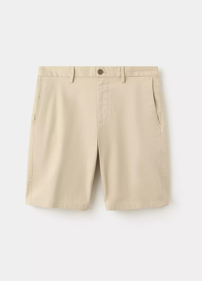 Beige knee-length shorts with side pockets, belt loops, and a button fastening, displayed against a plain white background—perfect for channelling the laid-back style often seen on celebrity couples on holiday.