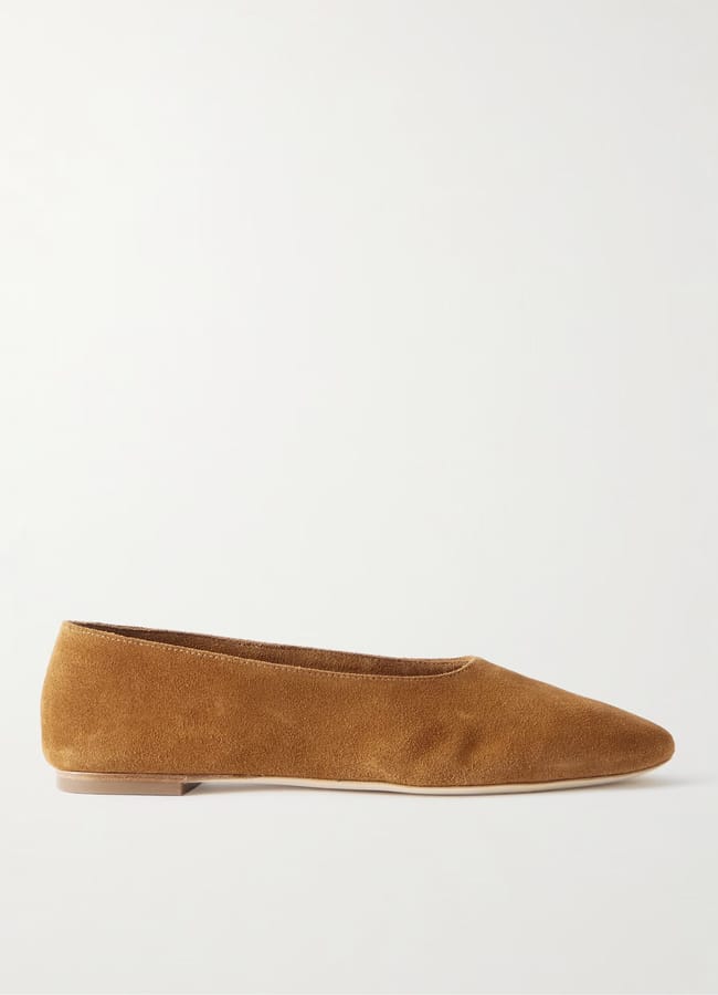 A single brown suede ballet flat shoe is shown in a side profile view on a plain white background, perfect for the season and now available during our summer sale.