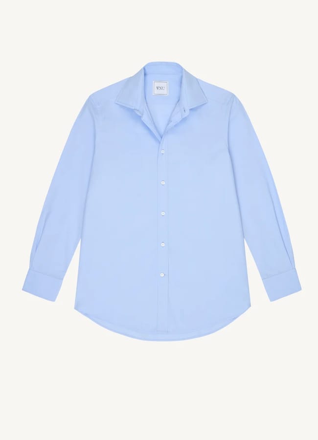 Light blue, long-sleeve button-up shirt with a collar, displayed flat against a white background. With its relaxed fit and white buttons down the front, this piece is perfect for oversized shirt outfit ideas.