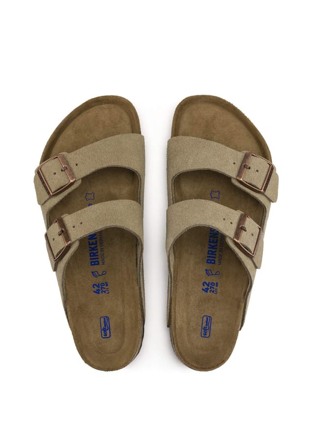 A pair of beige double-strap sandals with cork soles and metal buckles, shown from above on a white background—the perfect laid-back footwear choice for Celebrity Couples On Holiday.
