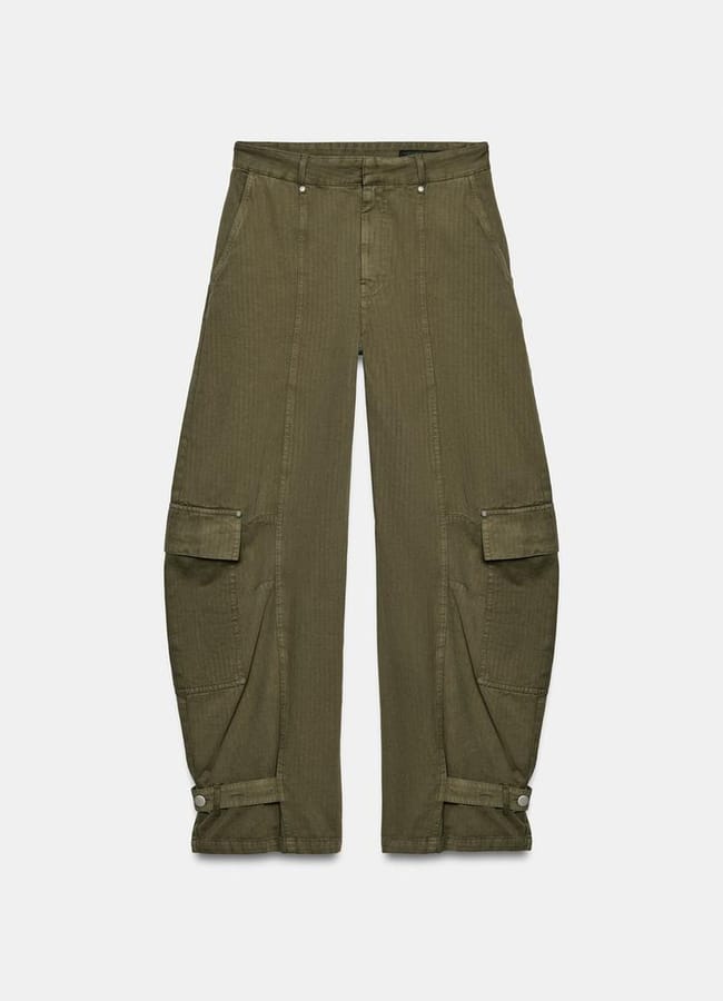 Olive green cargo trousers with a relaxed fit, large side flap pockets, seam detailing, and adjustable straps at the ankles—perfect for oversized shirt outfit ideas—displayed flat on a white background.
