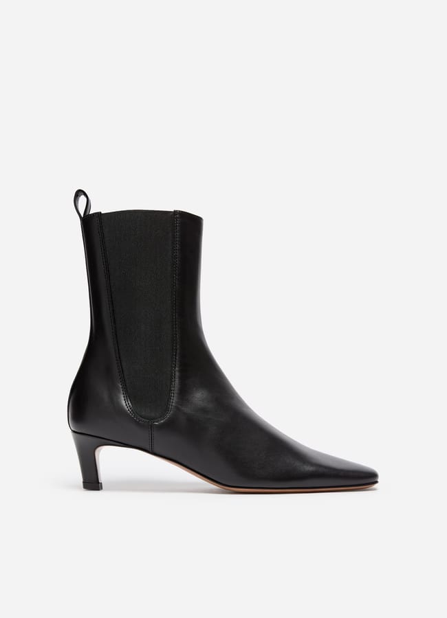 Black leather ankle boot with a low heel, pointed toe, and elasticated side panel, shown in side profile against a plain white background—an effortlessly chic style inspired by minimalist high street brands.