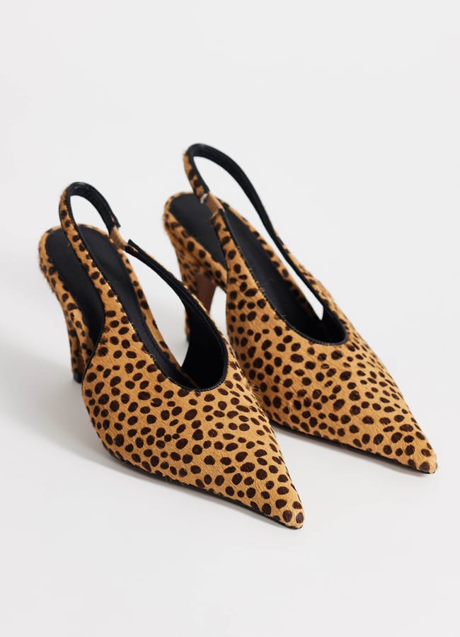 A pair of sexy heels featuring a pointed toe, leopard print high-heeled slingback design with black insoles, displayed on a white background.