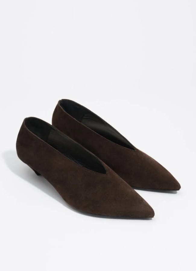 A pair of dark brown suede flats with pointed toes and a low heel, placed side by side on a white background—these fashion pieces offer an instant wardrobe upgrade.