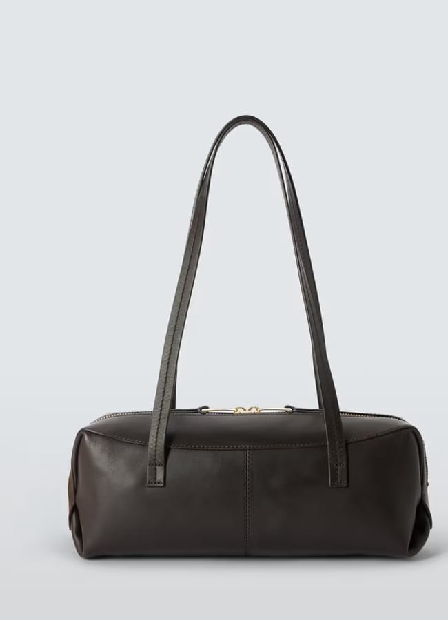 A rectangular, dark brown leather handbag with two long, thin shoulder straps—reminiscent of designs from minimalist high street brands—is shown against a light grey background.