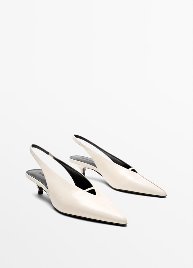 A pair of white pointed-toe slingback sexy heels with low heels, displayed on a plain white background.