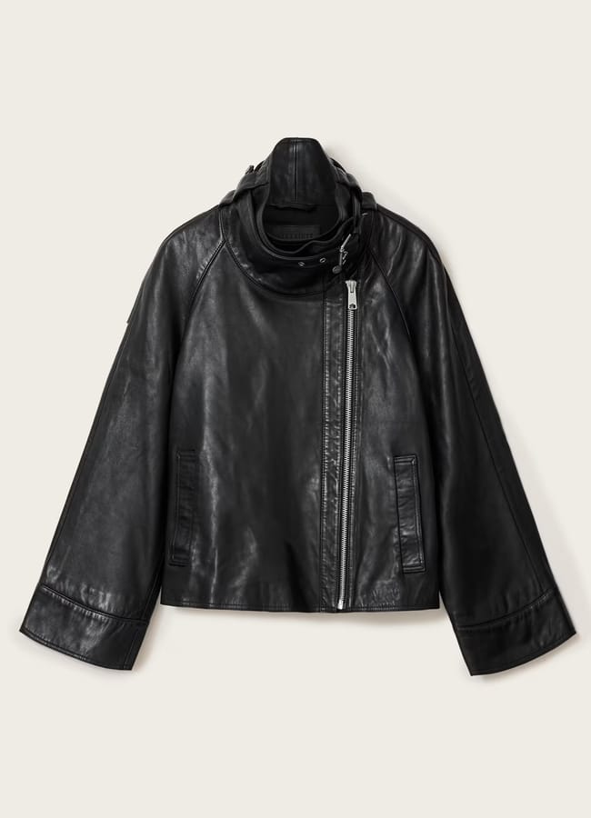 Black leather jacket with a high collar, an asymmetrical silver zip, and wide sleeves—one of the best women’s leather jackets.
