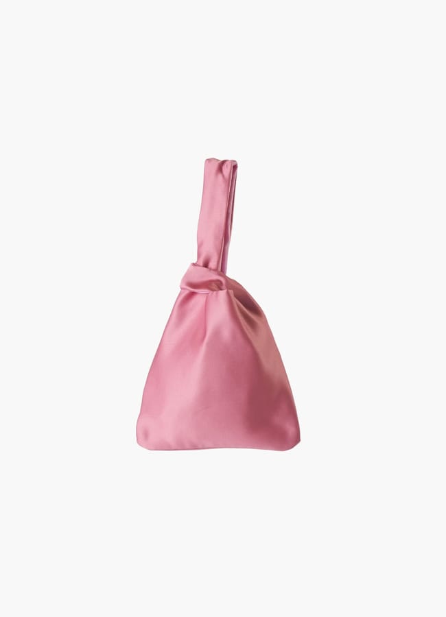 Small pink satin handbag with a knot handle from a black owned fashion brand.