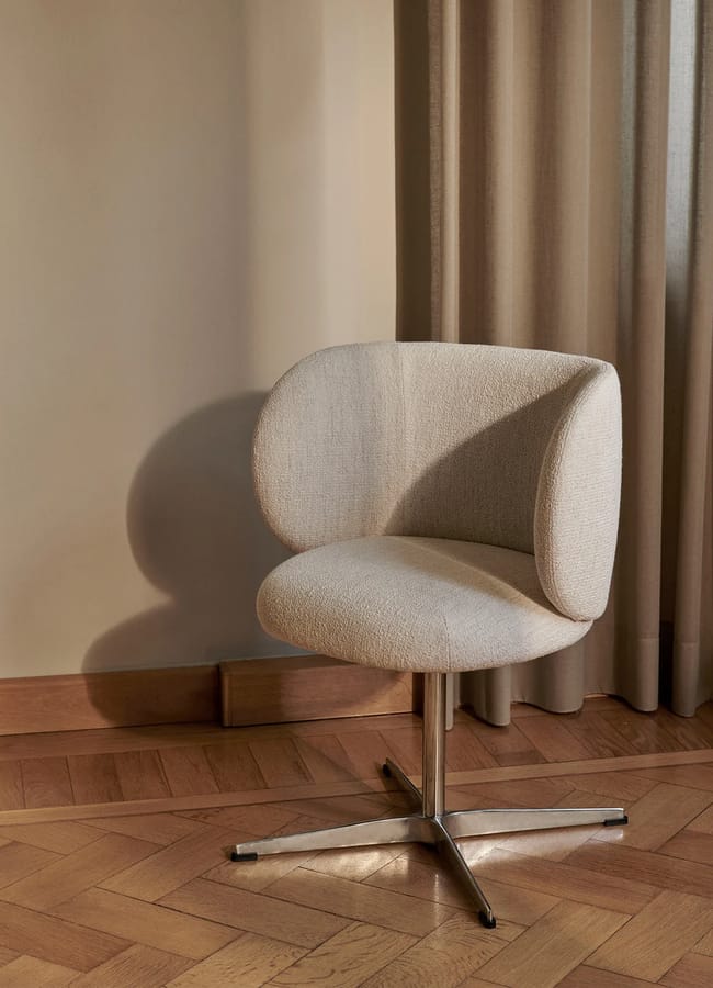 Off-white bouclé upholstered swivel chair with a curved backrest on a four-legged metal base.