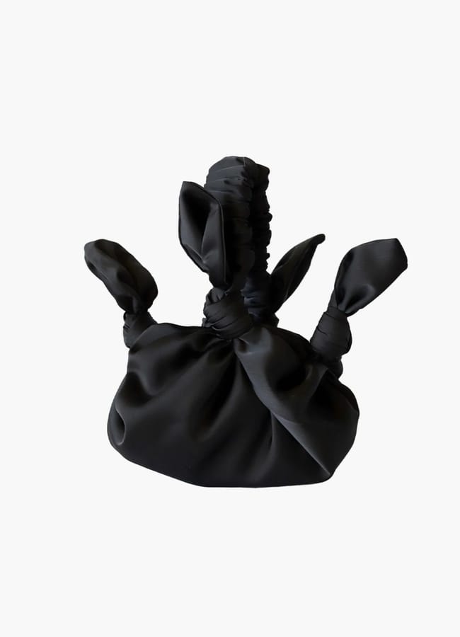 Black fabric handbag with a knotted design and gathered handle from a Black-owned fashion brand.