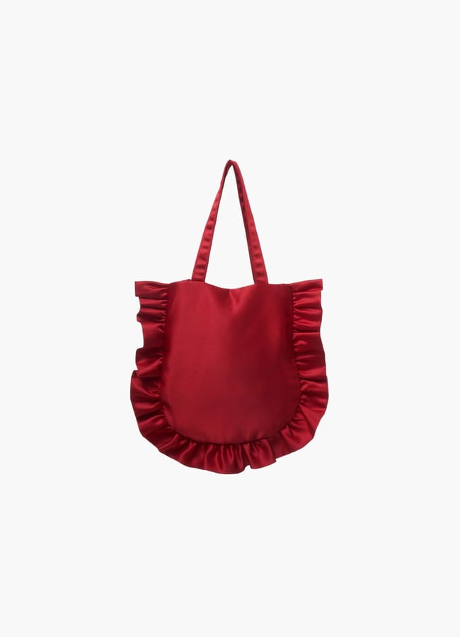 Red tote bag from a black owned fashion brand, featuring ruffled edges and two shoulder straps.