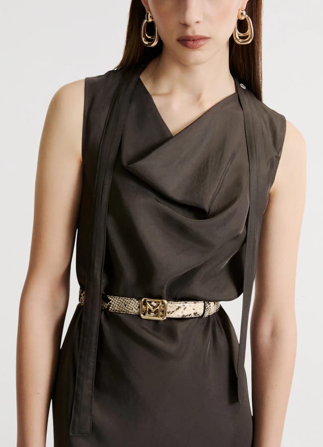A sleeveless dark brown dress with a cowl neckline, cinched at the waist with a snakeskin-patterned belt featuring a gold buckle, worn with large gold hoop earrings.
