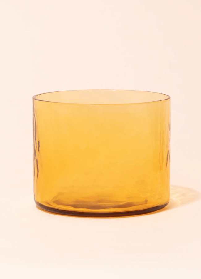 A short, wide amber glass tumbler perfect for autumn tablescape ideas.