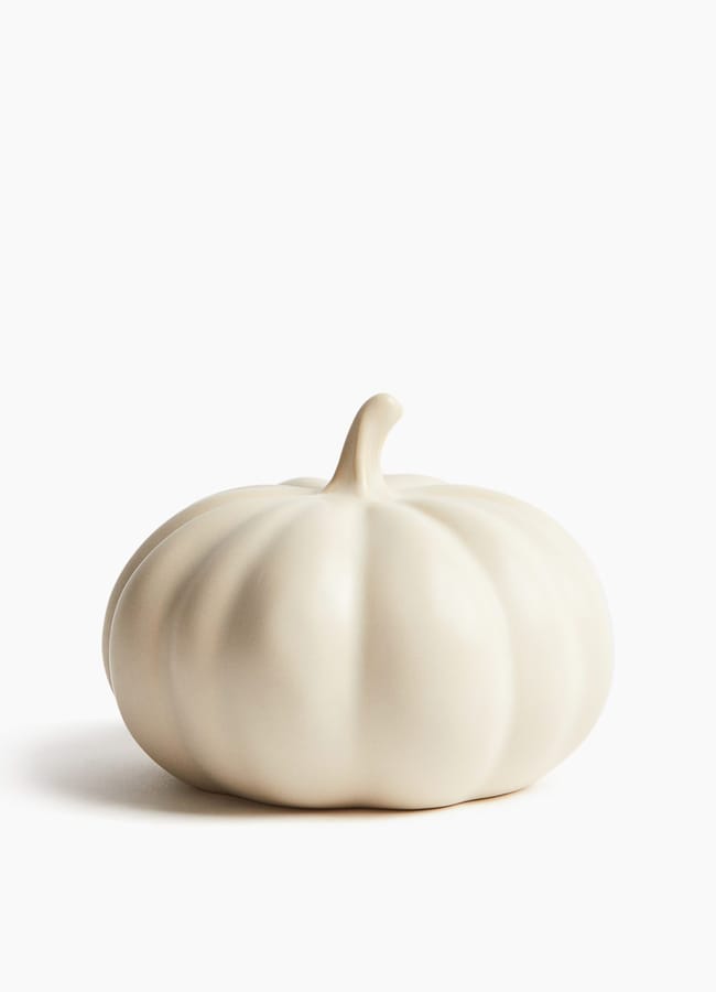 A smooth, matt, off-white decorative pumpkin for autumn tablescape ideas.