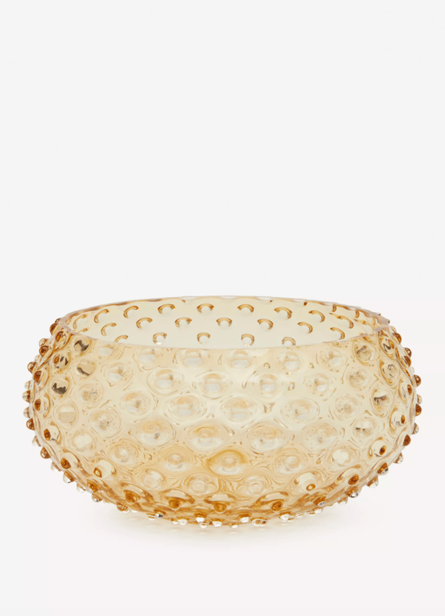 Amber-coloured glass bowl with a textured, raised dot pattern on the exterior, perfect for autumn tablescape ideas.
