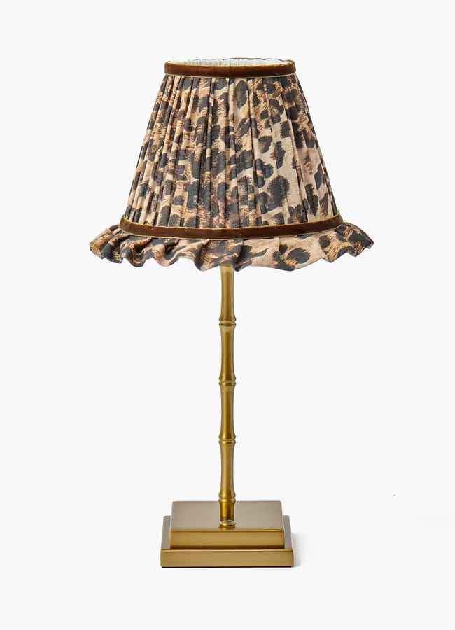 Table lamp with a gold-tone bamboo-style base and a ruffled leopard-print lampshade, perfect for autumn tablescaping ideas.