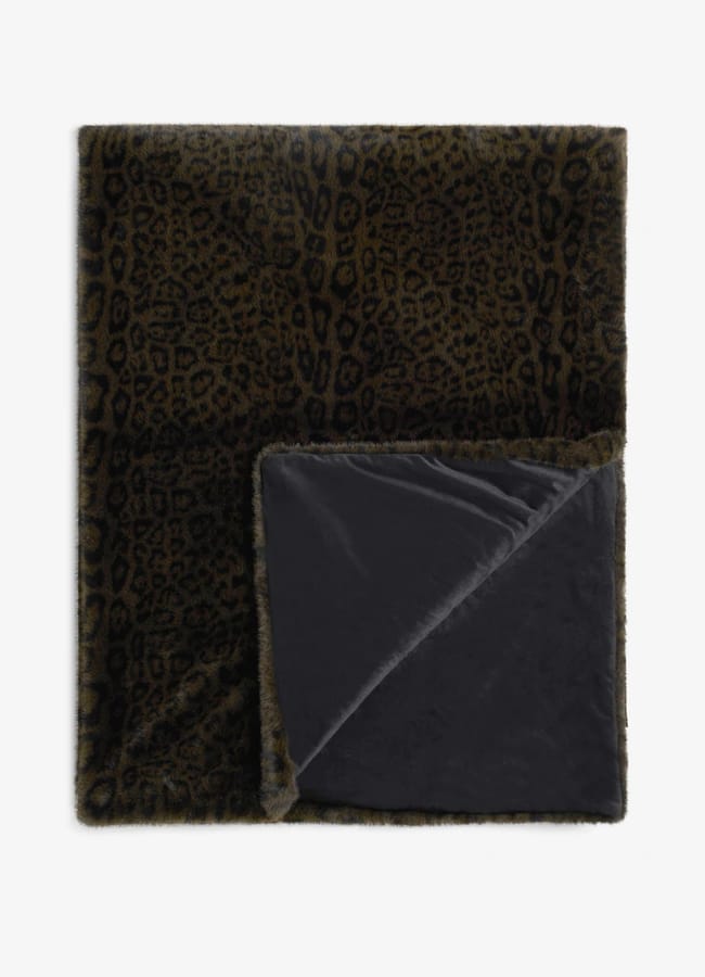 A Rockett St George folded throw blanket featuring a brown and black leopard print faux fur side and a solid black underside.