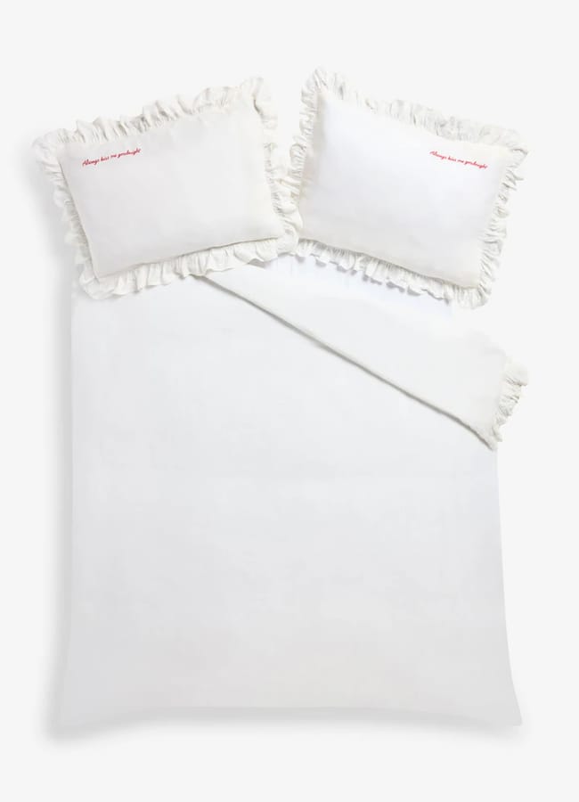 White Rockett St George duvet cover and two frilled pillowcases embroidered with the words Always kiss me goodnight in red.