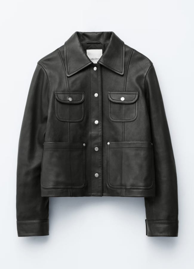 Black leather jacket with a pointed collar, button front, and four front pockets; one of the best women's leather jackets.