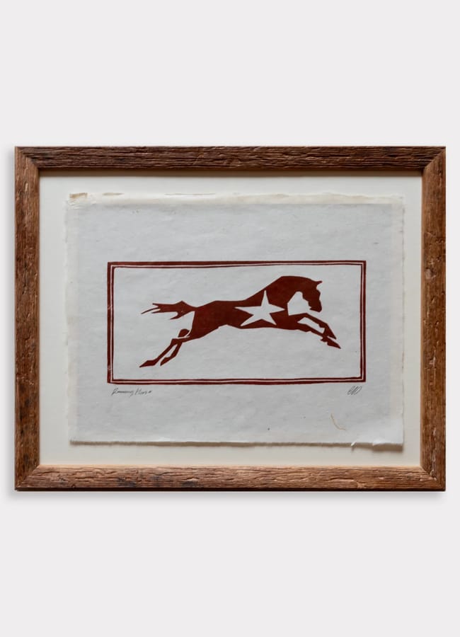 Framed print of a dark red silhouette of a leaping horse with a white star on its side, enclosed in a rectangular border; a piece of affordable wall art.