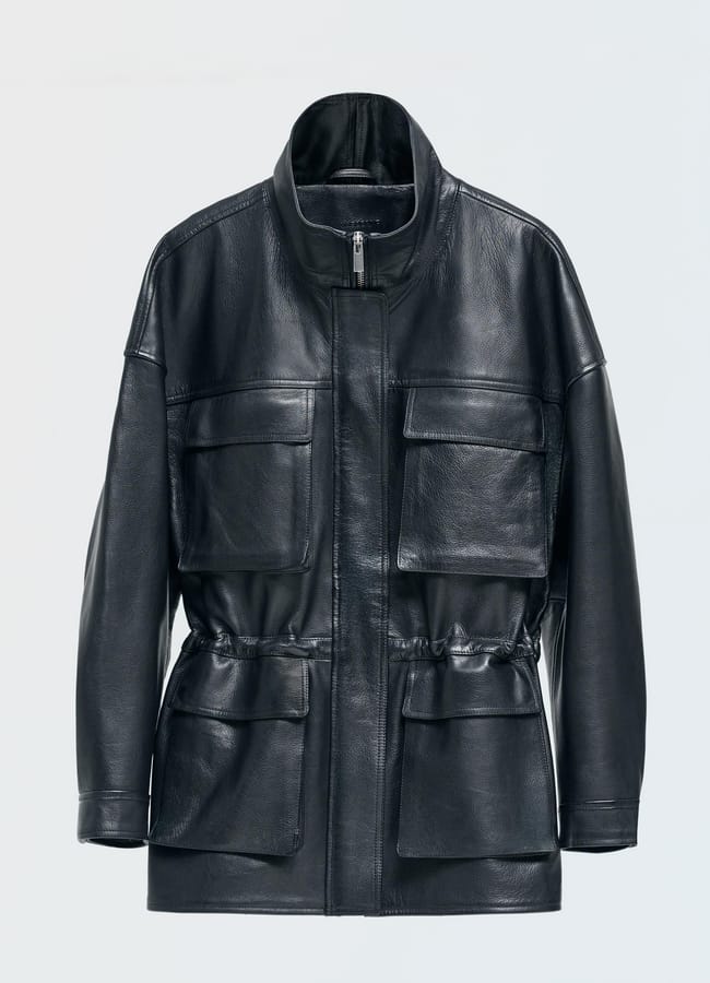 Black leather utility jacket featuring a stand collar, front zip, and four flap pockets, standing out as one of the best women’s leather jackets.