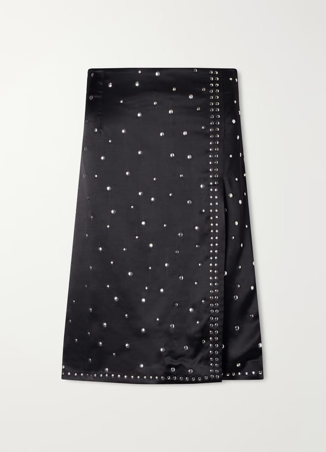 Black midi skirt from a British fashion brand, embellished with scattered silver studs and a vertical row of eyelets along a side slit.