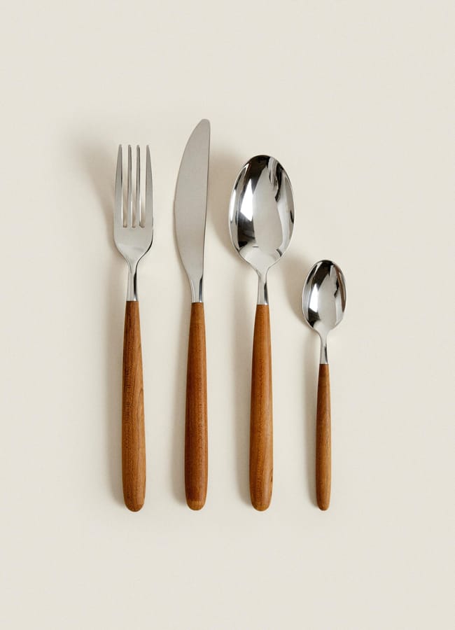 A four-piece stainless steel cutlery set with wooden handles, including a fork, knife, tablespoon, and teaspoon, perfect for autumn tablescape ideas.