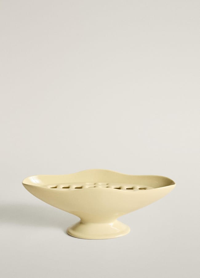 A pale yellow ceramic flower frog bowl on a pedestal base, perfect for autumn tablescape ideas.