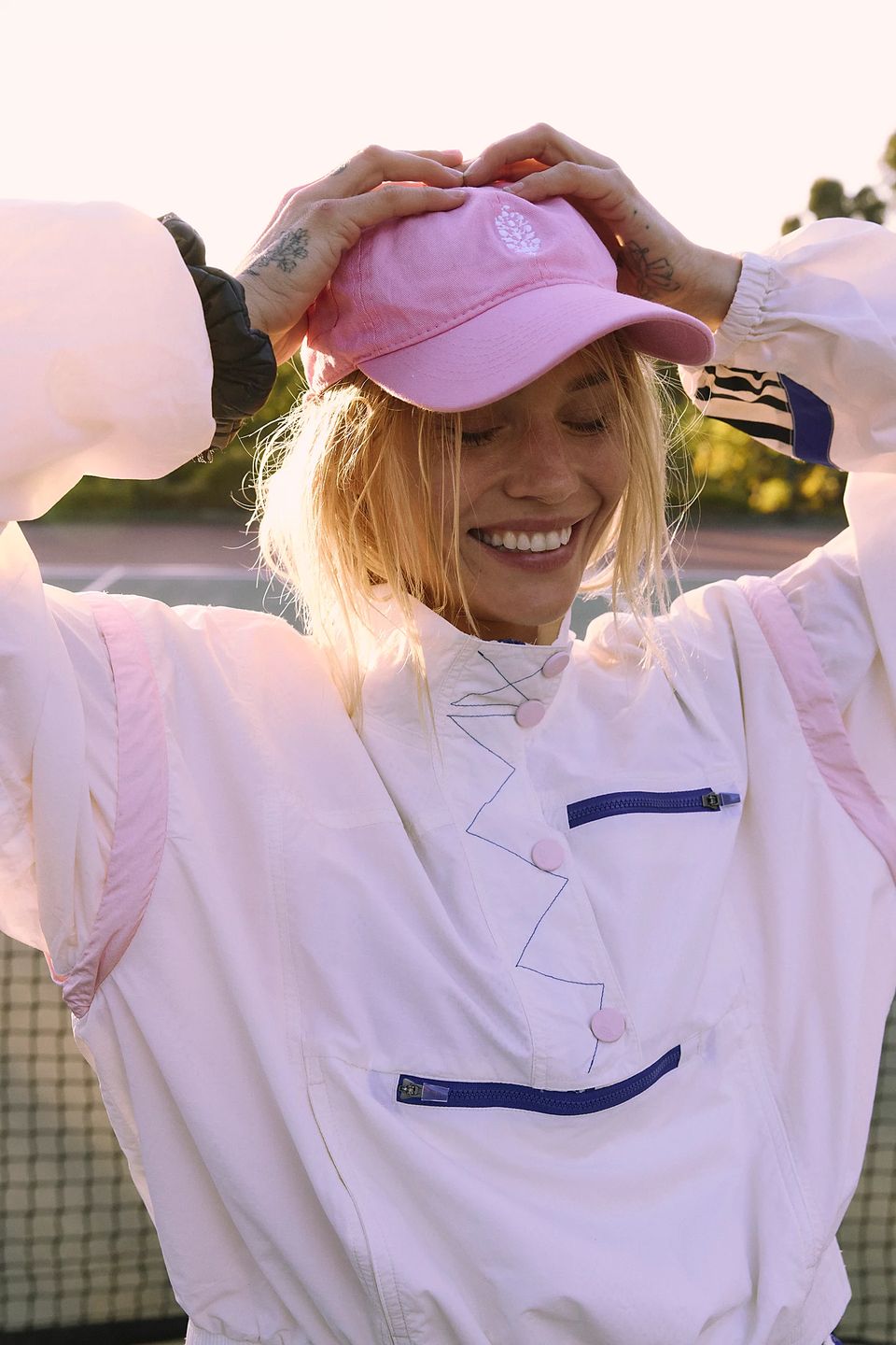 model in cap and sports jacket on tennis court