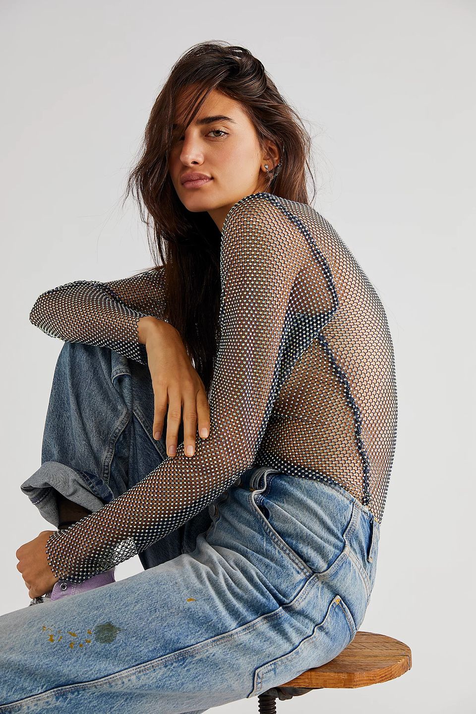 model kneeing wearing mesh and rhinestone top