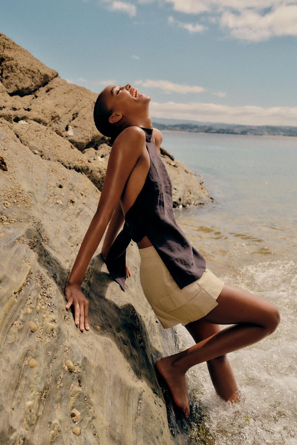 model leaning against rock wearing Flowing Halter Top With Open Back