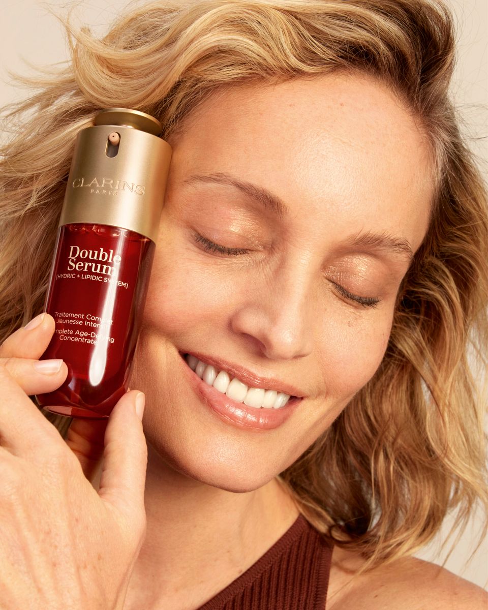 close up of model holding clarins double serum